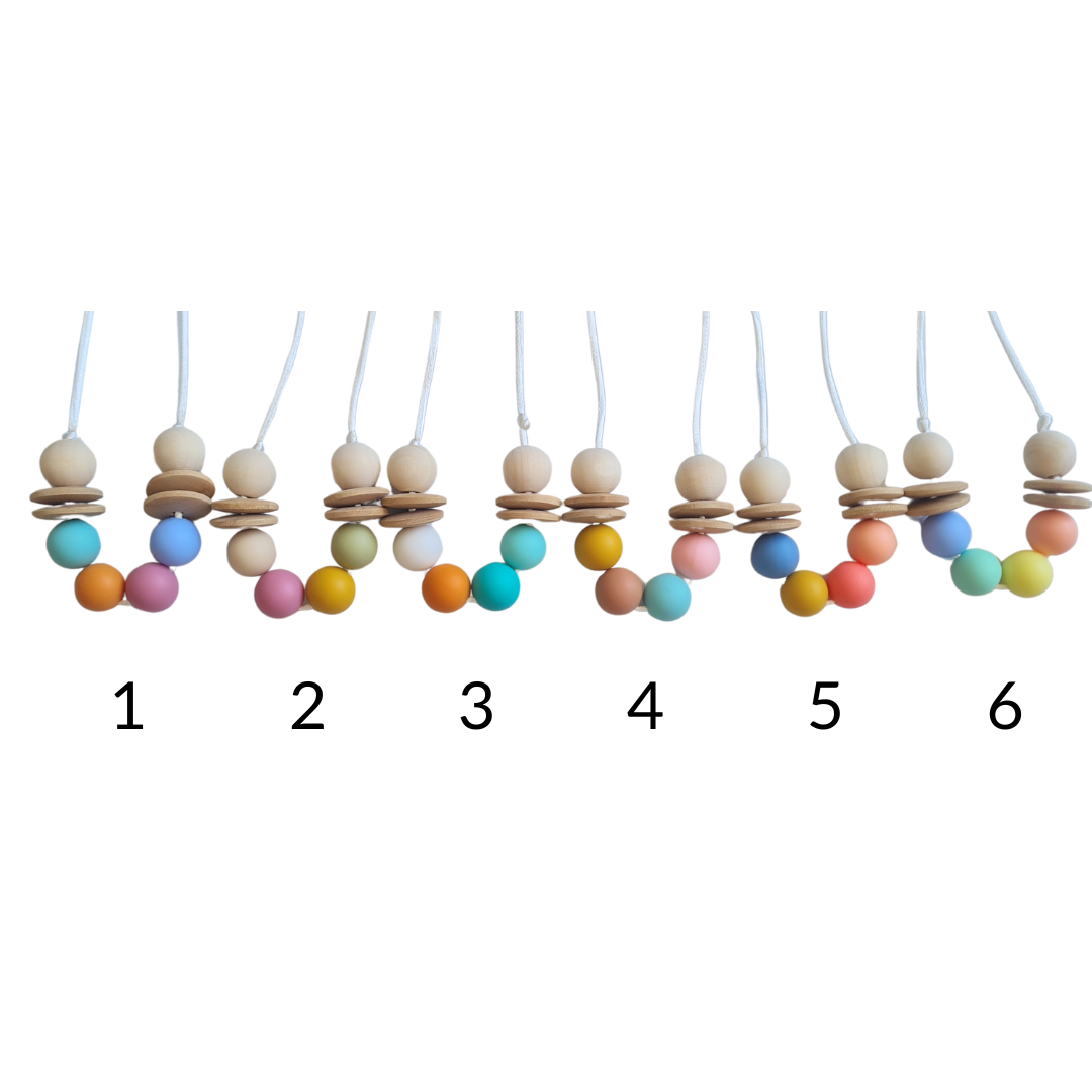 Collar sensorial de lactancia con cuentas en colores alegres, perfecto para llamar la atención del bebé y aliviar la dentición.