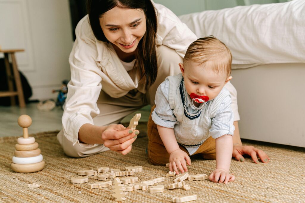mama y bebe jugando con juguetes de madera que agudizan la motricidad fina